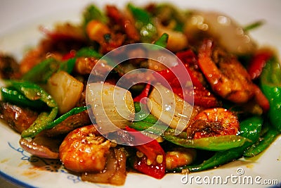 Chinese dish fried vegetables with shrimps in a sweet sauce, served on a white plate. Beijing, China. Stock Photo