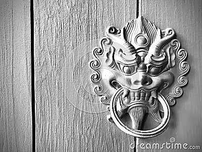 Chinese dragon head door knocker on wooden door. Monochrome photography. Stock Photo