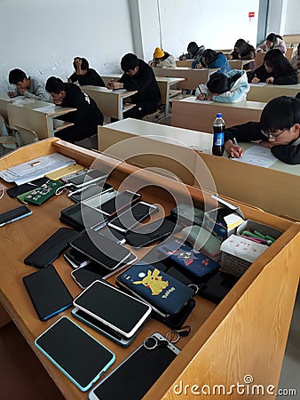 Chinese English students having an exam at college and their mobile phones. Editorial Stock Photo