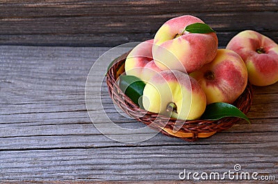 Chinese flat donut peaches in the basket on on old wooden table also known as Saturn donut, Doughnut peach, Paraguayo.Healthy eati Stock Photo