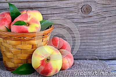 Chinese flat donut peaches in the basket on on old wooden table also known as Saturn donut, Doughnut peach, Paraguayo.Healthy eati Stock Photo