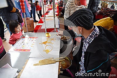 Chinese folk craftsman who is making sugar paintings Editorial Stock Photo