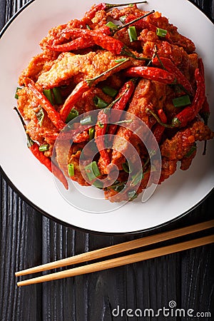 Chinese food chicken in Schezwan sauce close-up on a plate. Vertical top view Stock Photo