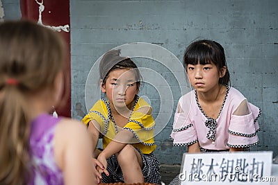 Chinese girls looking at a Caucasian girl Editorial Stock Photo