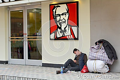 Chinese homeless on sit outside KFC fast food restaurant Editorial Stock Photo