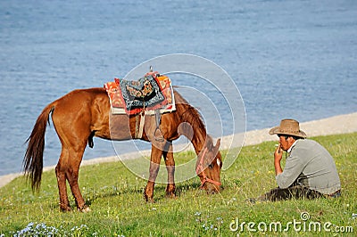 Chinese Kazakh herdsmen with horse at Sailimu lak Editorial Stock Photo