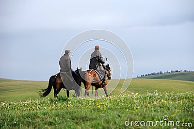 Chinese Kazakh herdsmen riding horse in grasslan Editorial Stock Photo
