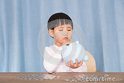 Chinese kids are tossing the piggy bank to see if there are coins Stock Photo