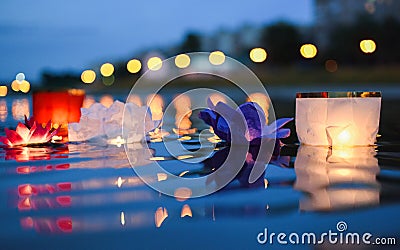 Chinese lanterns floating in river at night with city lights Stock Photo