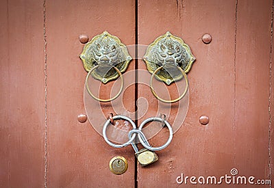 Chinese lion doorknob and padlock on close brown wood door background Stock Photo