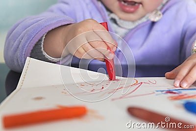 Little daughter using oil painting stick to scrawl Stock Photo
