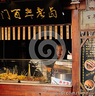 Chinese man at grilled meat food stand Editorial Stock Photo