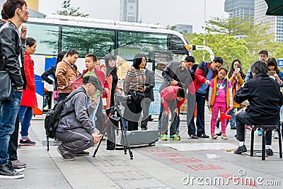 A Chinese man watching his camera and recording a man playing Chinese traditional musical instument Erhu in Shenzhen, China Editorial Stock Photo