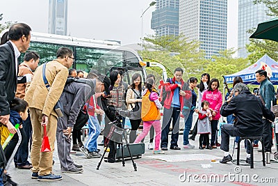 A Chinese man watching his camera and recording a man playing Chinese traditional musical instument Erhu in Shenzhen, China Editorial Stock Photo