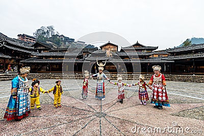 The Chinese miao women and kids wearing traditional clothes and dancing in open opera house of Xijiang Qianhu Miao Village One Editorial Stock Photo