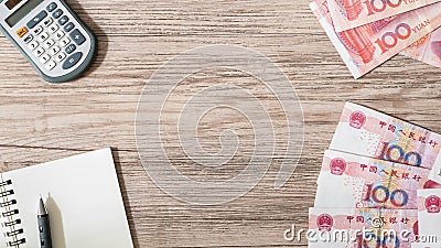 Chinese Yuan bank notes currency and Calculator, notebook, pencil on wooden background Stock Photo