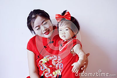 Chinese mother and child in red cheongsam have fun Stock Photo