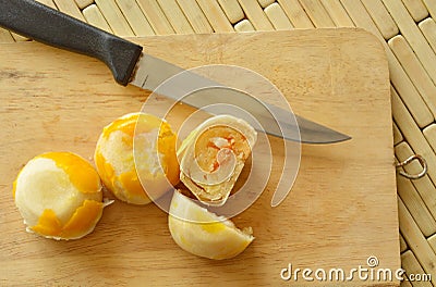 Chinese pastry stuffed sweet mashed bean and salty egg yolk on wooden chop block Stock Photo