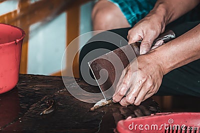 Chinese person peeling skin off small fish Stock Photo