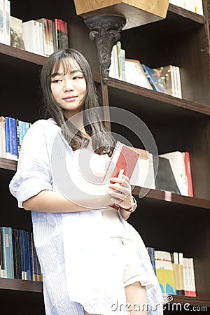 Chinese Portrait of young beautiful woman hold education books In Bookstore Stock Photo