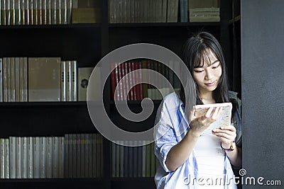 Chinese Portrait of young beautiful woman reads Book In Bookstore Stock Photo