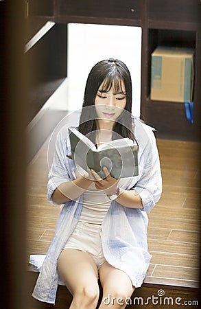 Chinese Portrait of young beautiful woman reads Book In Bookstore Stock Photo