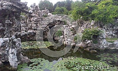 Chinese garden with waterlily pond and grey rock formations Stock Photo