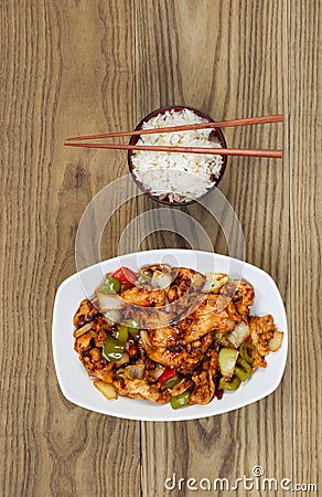 Chinese Spicy Chicken Dish with Rice in bowl on faded wood Stock Photo