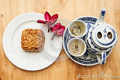 Chinese tea set with mooncake and red flowers in natural light Stock Photo