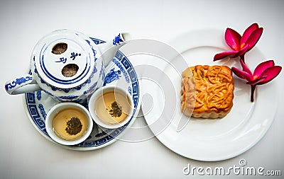 Chinese tea set with mooncake and red flowers in natural light Stock Photo