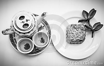 Chinese tea set with mooncake and red flowers in natural light Stock Photo