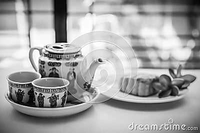 Chinese tea set with mooncake and red flowers in natural light Stock Photo