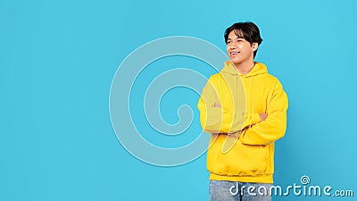 Chinese Teen Boy Looking Aside At Free Space, Blue Background Stock Photo