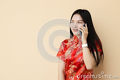 Chinese teen girl phone calling with friend dressing Qipao traditional cloth Stock Photo