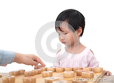 Chinese three-year-old girl seriously plays Chinese chess with her opponent Stock Photo