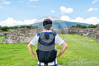 A chinese tourist in the ruins of the architecturally significant Mesoamerican pyramids and green grassland located at at Editorial Stock Photo