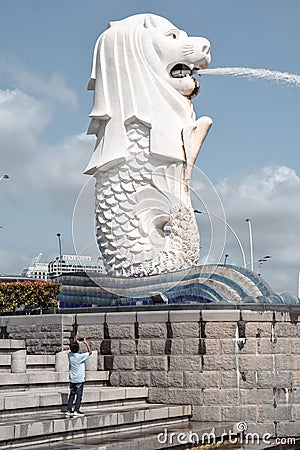 Chinese tourist taking a photo of the Merlion statue in the Merlion park in Singapore Editorial Stock Photo