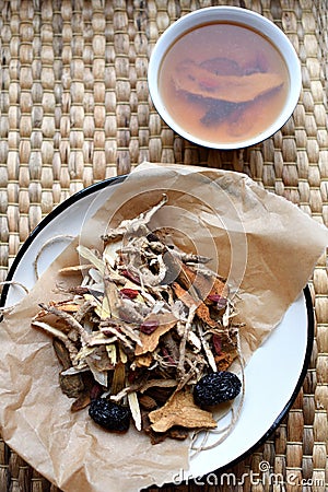 Chinese traditional medicine script. Herbal tea with jujubes, goji berries, gingseng roots and others on parchment paper on neutra Stock Photo