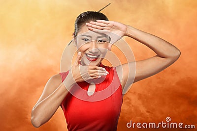 Chinese woman in cheongsam dress framing her face with hand Stock Photo