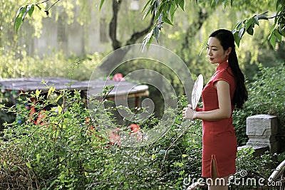 Chinese woman in cheongsam by a lake in Mudu ancient town Stock Photo