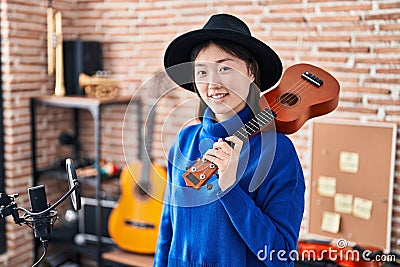 Chinese woman musician smiling confident holding ukulele at music studio Stock Photo