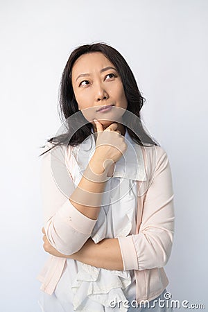 Thoughtful Asian business woman posing against white background. Stock Photo