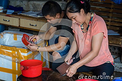 Chinese workers peeling skin off small fish Editorial Stock Photo