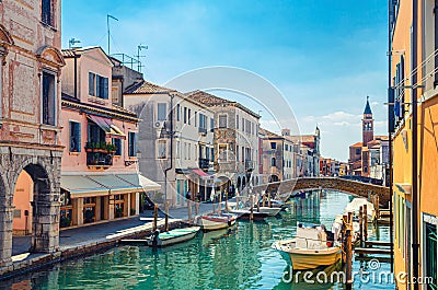 Chioggia cityscape with narrow water canal Vena with moored multicolored boats Stock Photo