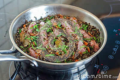 Chipolata sausages cooked with lentils, carrots and parsley Stock Photo