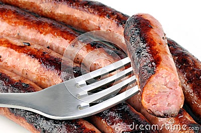 Close up on a chipolata stuck on a fork Stock Photo