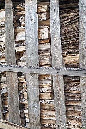 Chipped wood and sawn wood waste, stacked behind a partition of old planks. The concept of nature protection. Stock Photo