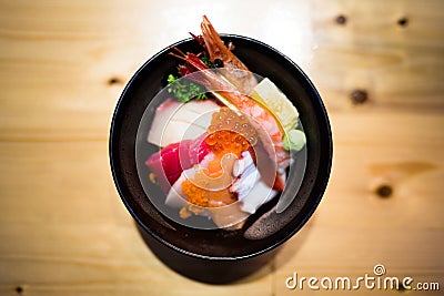 Chirashi sushi, Japanese food rice bowl with raw salmon sashimi, mixed seafood, top view, darken edge, center aligned with copy sp Stock Photo