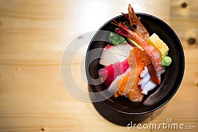 Chirashi sushi, Japanese food rice bowl with raw salmon sashimi, mixed seafood, top view, darken edge Stock Photo