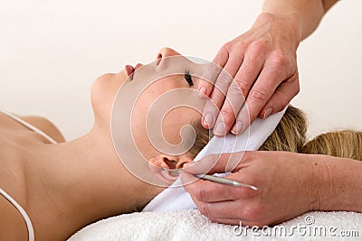 Chiropractor applying ear acupuncture techniques. Stock Photo